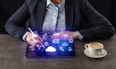 Yukarıdaki uygulama simgeleriyle tablet üzerinde çalışan iş kadın
