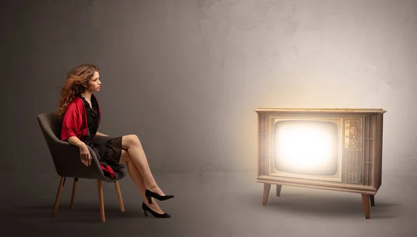 Young lady watching to a vintage television — Stock Photo, Image