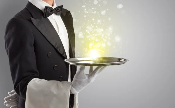 Waiter serving mysterious light on tray — Stock Photo, Image