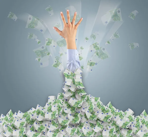 Hand buried in cash pile and trying to get out — Stock Photo, Image