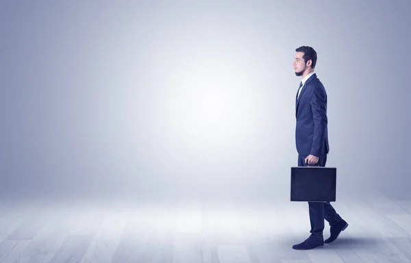 Empresario caminando frente a una pared vacía — Foto de Stock