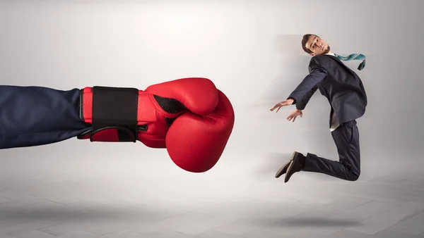 Giant hand gives a kick to a small businessman — Stock Photo, Image