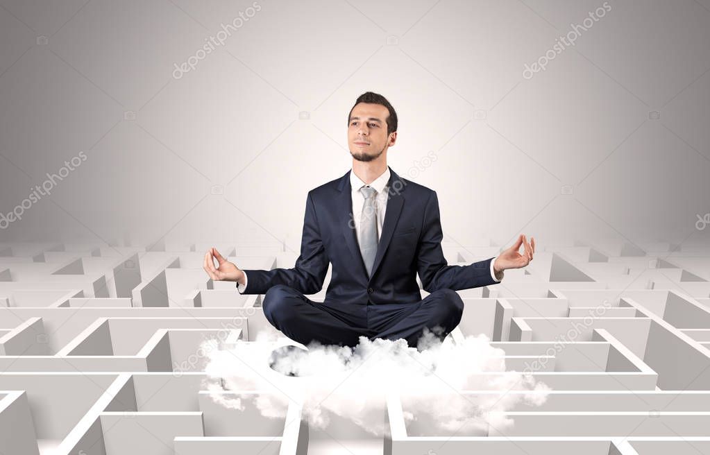 Businessman meditates on a cloud with maze concept