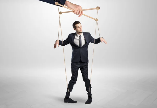 Puppet businessman leaded by a huge hand — Stock Photo, Image