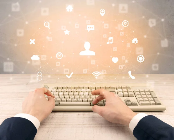 Elegant businessman hand typing social media icons around — Stock Photo, Image