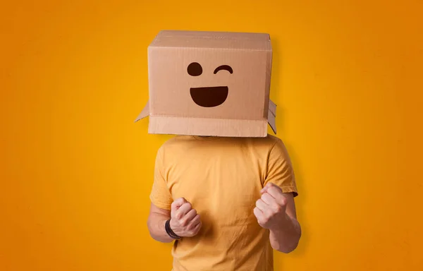 Смешной человек, улыбающийся головой из картонной коробки — стоковое фото