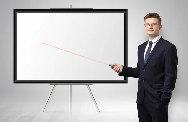 Businessman with laser pointer and copyspace white wall — Stock Photo, Image