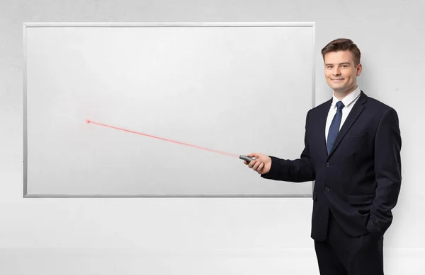 Businessman with laser pointer and copyspace white blackboard — Stock Photo, Image