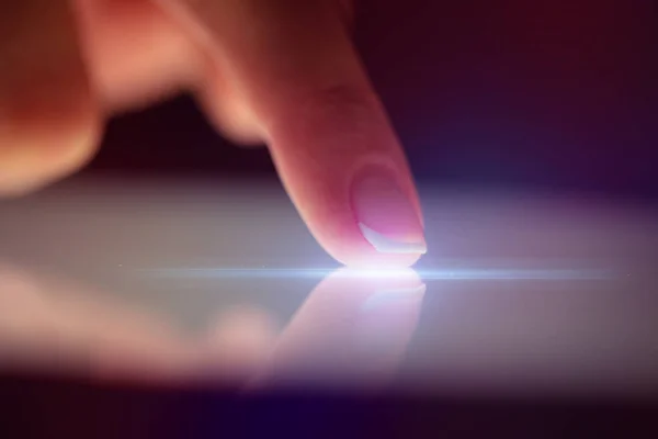 Прикосновение пальца планшета с темным фоном — стоковое фото