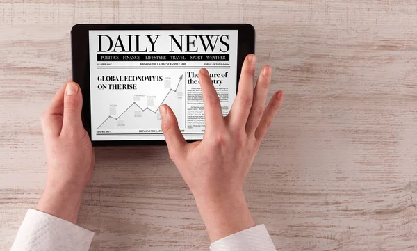 Hand with tablet reading news — Stock Photo, Image