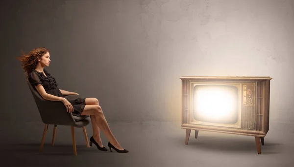 Young lady watching to a vintage television — Stock Photo, Image