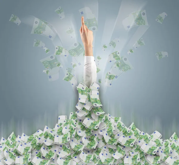 Hand buried in cash pile and trying to get out — Stock Photo, Image