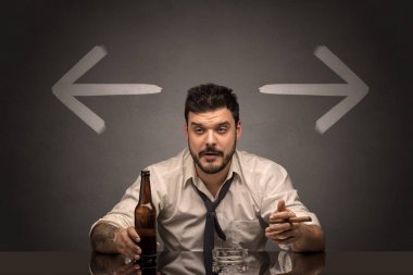 Sarhoş adam oklarla masada oturan