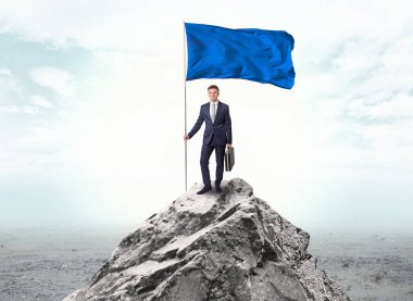 İşadamı üst tarafındaki bir bayrak tutan dağ