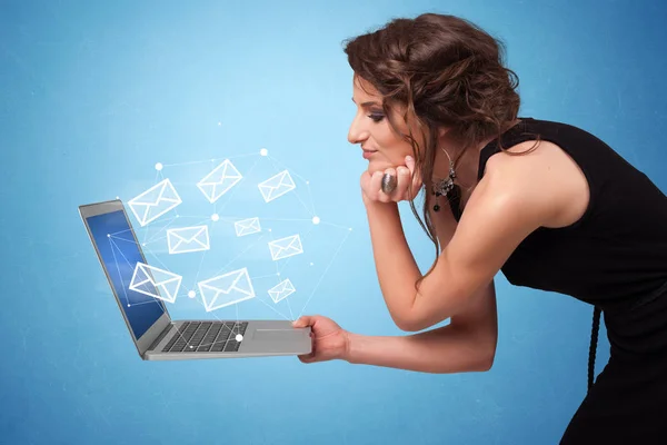 Женщина держит ноутбук с онлайн символами — стоковое фото