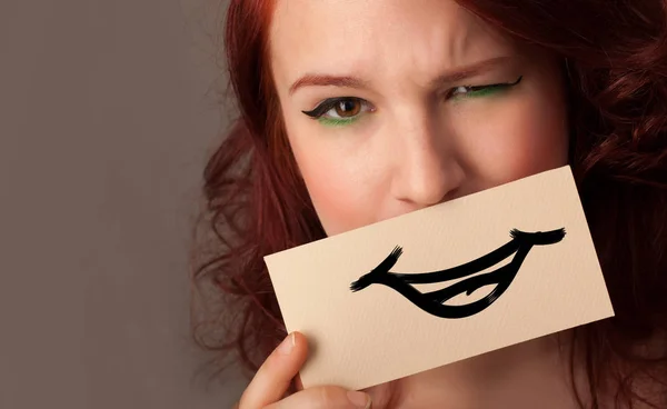 Person holding in front of her mouth a card — Stock Photo, Image