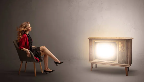 Jeune femme regardant une télévision vintage — Photo
