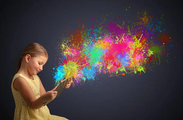 Girl holding tablet with colourful splash around — Stock Photo, Image