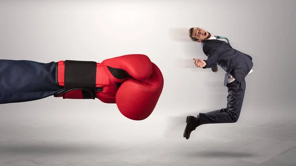 Giant hand gives a kick to a small businessman — Stock Photo, Image
