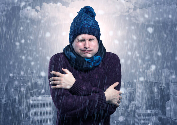 Boy freezing in cold weather with city concept