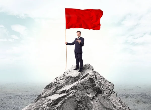 Empresario en la cima de una bandera de la montaña — Foto de Stock