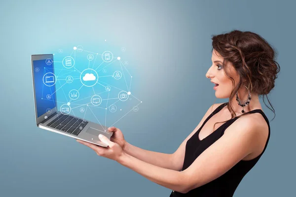Kobieta trzyma laptopa z chmury na podstawie koncepcja systemu — Zdjęcie stockowe