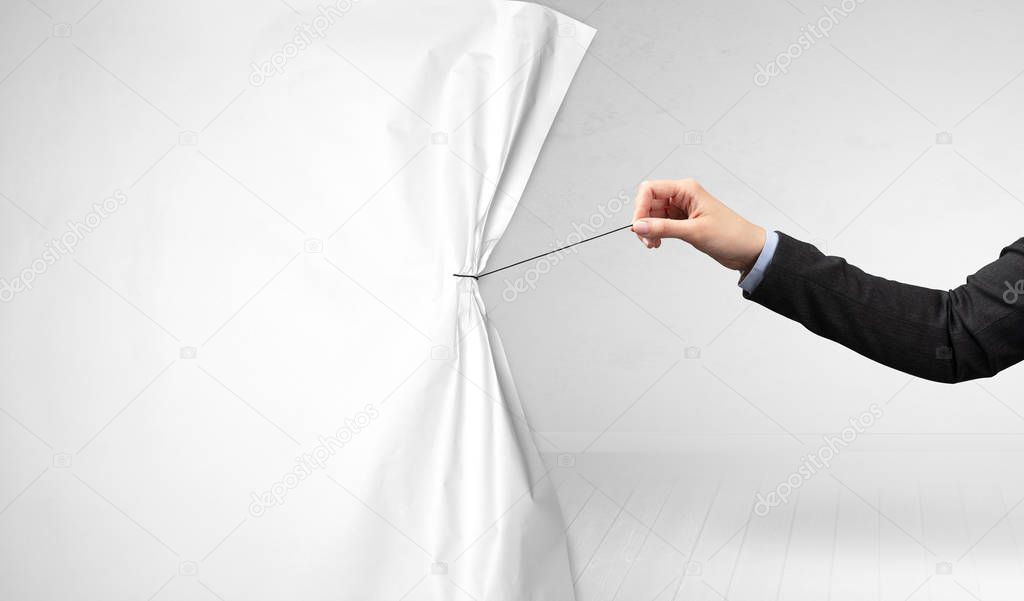 hand pulling white paper curtain