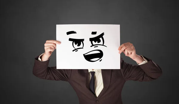 Person hält ein Papier mit lustigen Emoticons vor ihr Gesicht — Stockfoto