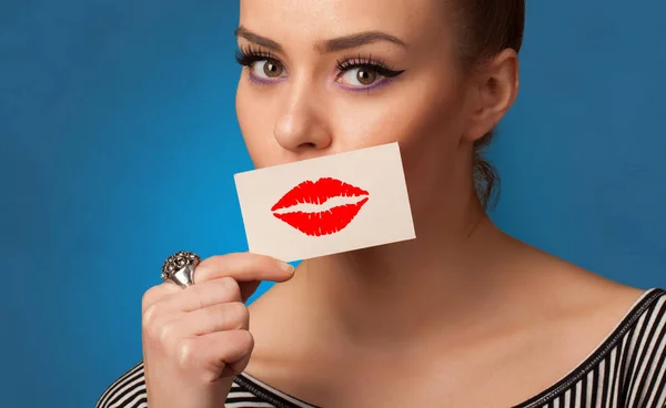 Pessoa sorrindo com um cartão na frente de sua boca — Fotografia de Stock