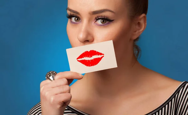 Persona sonriendo con una tarjeta delante de su boca — Foto de Stock