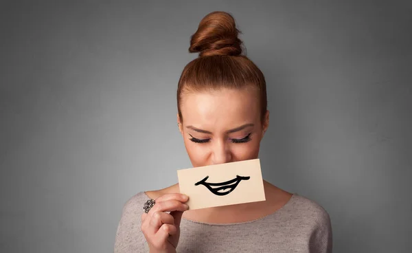 Person holding in front of her mouth a card — Stock Photo, Image