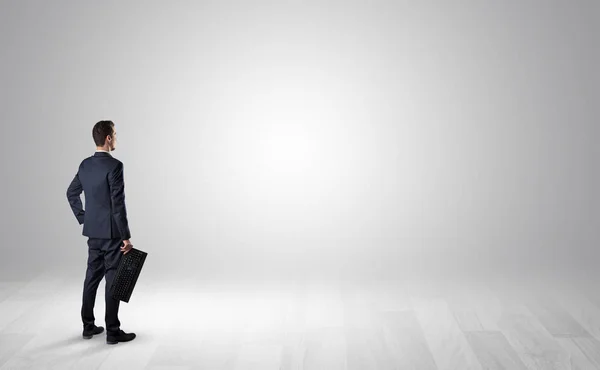 Man with object in his hand in an empty space — Stock Photo, Image