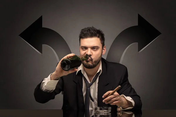 Dronken man zit aan tafel met pijlen rond — Stockfoto