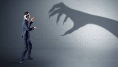 İşadamı korkunç el gölge ile mücadele