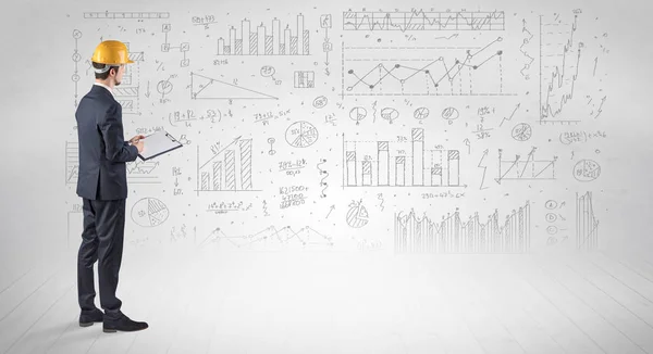 Mérnök gazdaság egy tervet, és állandó, grafikonok, diagramok és jelentések a háttérben — Stock Fotó