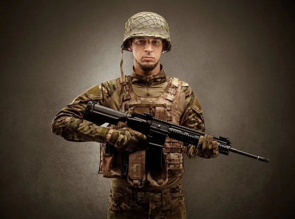 Agente soldado em um espaço escuro com braços — Fotografia de Stock
