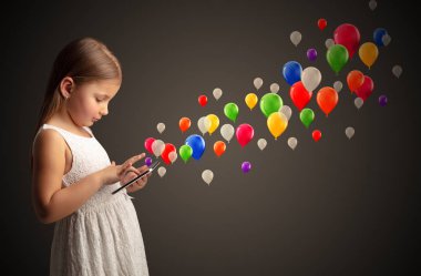 Kız holding tablet renkli balonlar ile