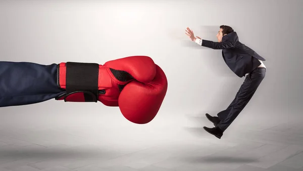 Mão gigante dá um chute a um pequeno empresário — Fotografia de Stock