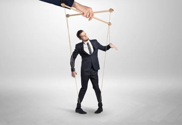 Puppet businessman leaded by a huge hand — Stock Photo, Image