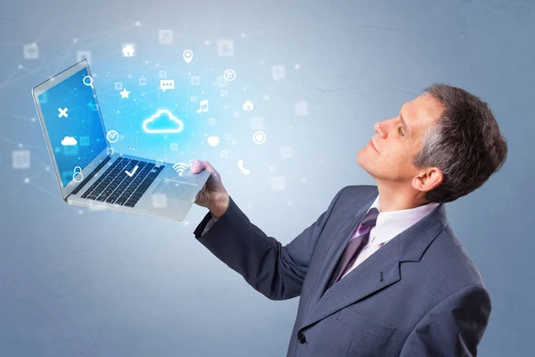 Hombre celebración de la computadora portátil con notificaciones del sistema basado en la nube —  Fotos de Stock