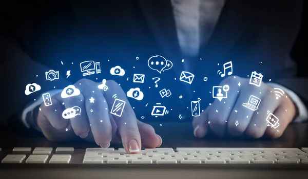 Mujer escribiendo en el teclado con iconos de aplicación alrededor —  Fotos de Stock