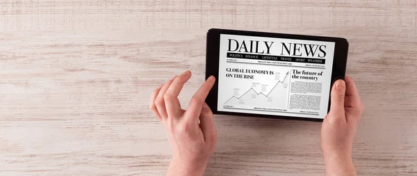 Hand med tablett läsa nyheter — Stockfoto
