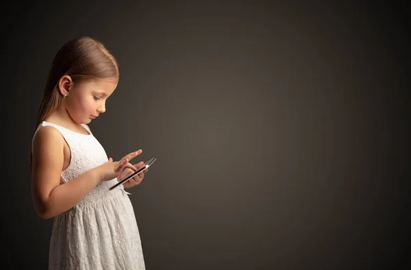 Schattig klein meisje tablet met donkere achtergrond — Stockfoto