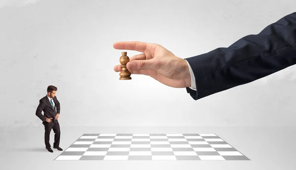 Little businessman playing chess with a big hand concept — Stock Photo, Image