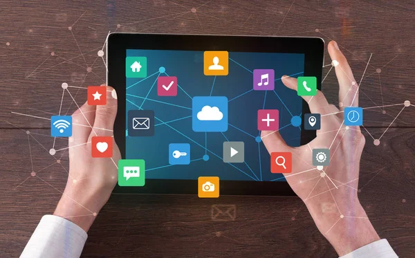 Hand using multitask tablet with application symbols and icons concept — Stock Photo, Image