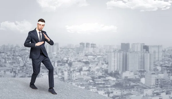 Suited karate man doing karate tricks on the top of a metropolitan city