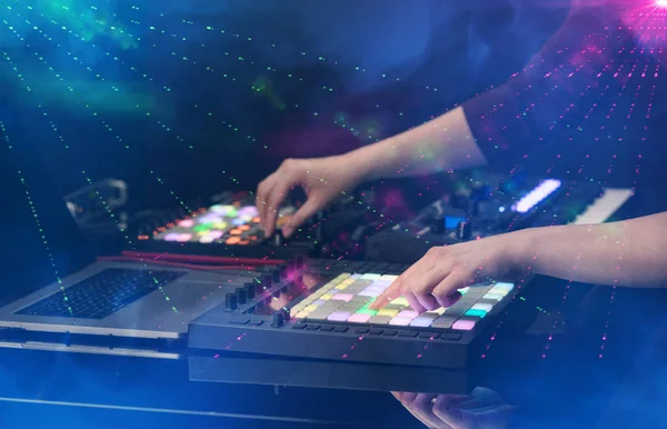 Mixing music on midi controller with party club colors around — Stock Photo, Image