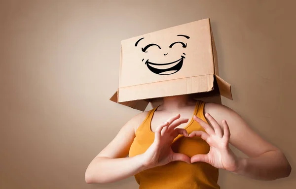 Молодая женщина с картонной коробкой на голове — стоковое фото