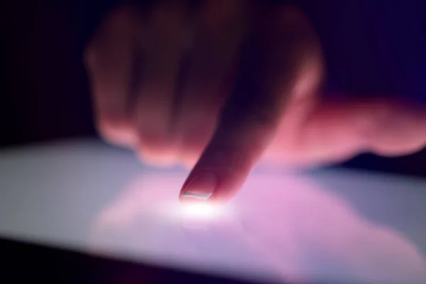 Finger touching tablet with dark background — Stock Photo, Image
