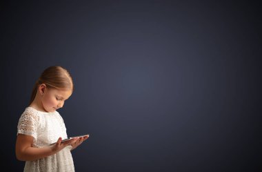 Tablet ile koyu arka plan kullanarak sevimli küçük kız